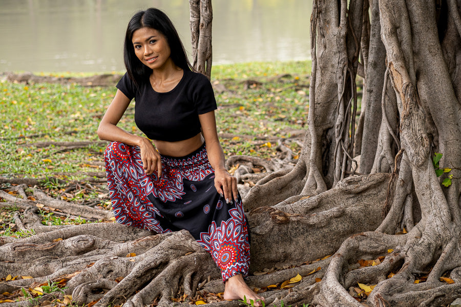 duas fotos de duas mulheres de pé na grama usando a calça pétala e a calça lótus da Calça Thai