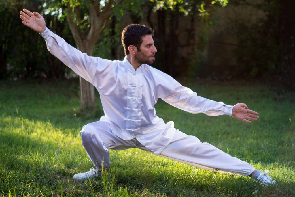 homem praticando tai chi usando roupa branca 