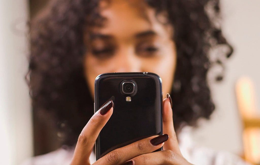 mulher segurando o celular e apontando a câmera para fazer compra pelo qr code do pix