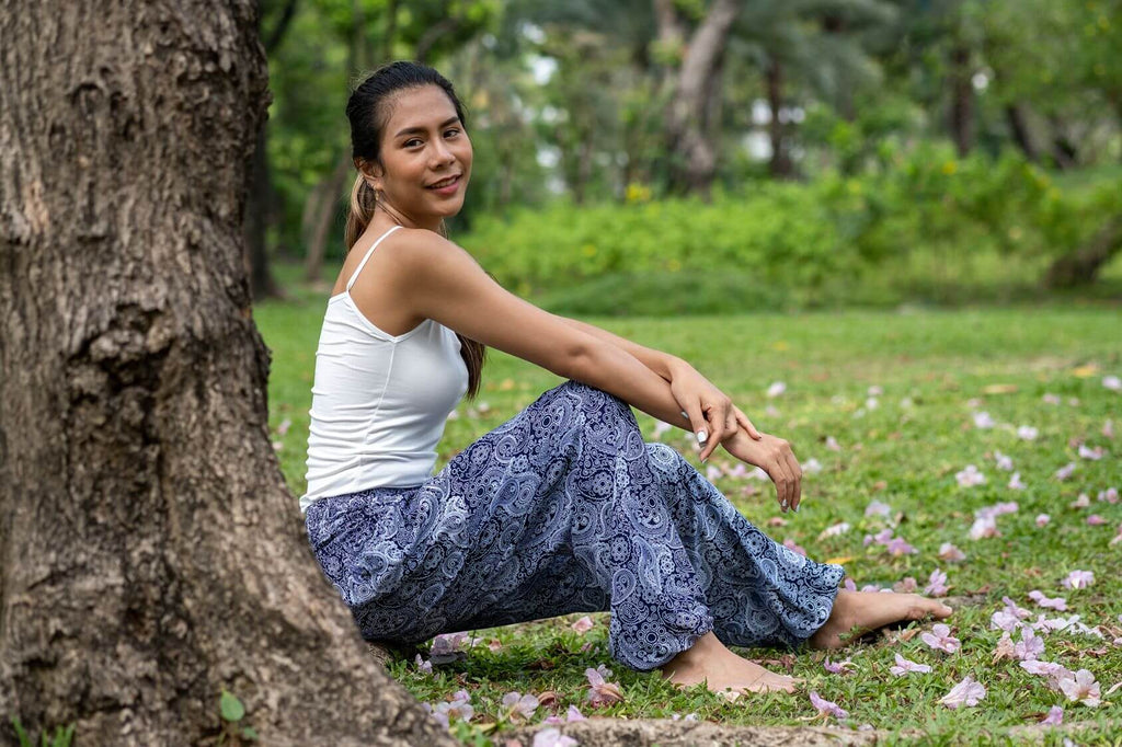 mulher sentada na grama usando calça flow cinza