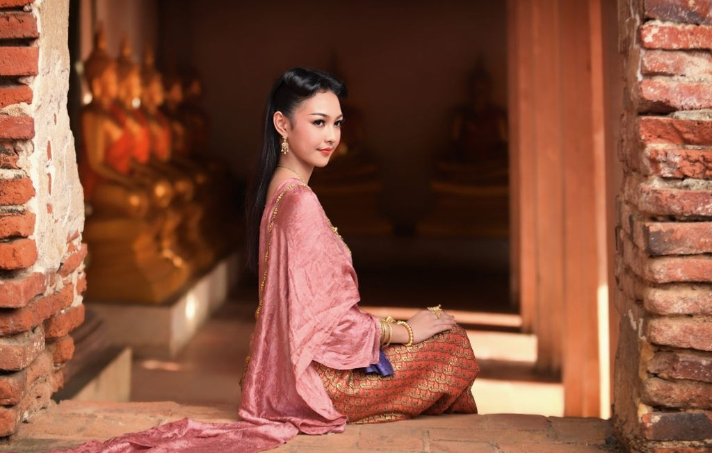 mulher jovem sentada usando roupa tradicional tailandesa